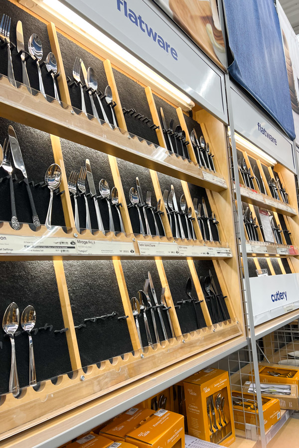 A lighted wall display showing various kitchen utensils.